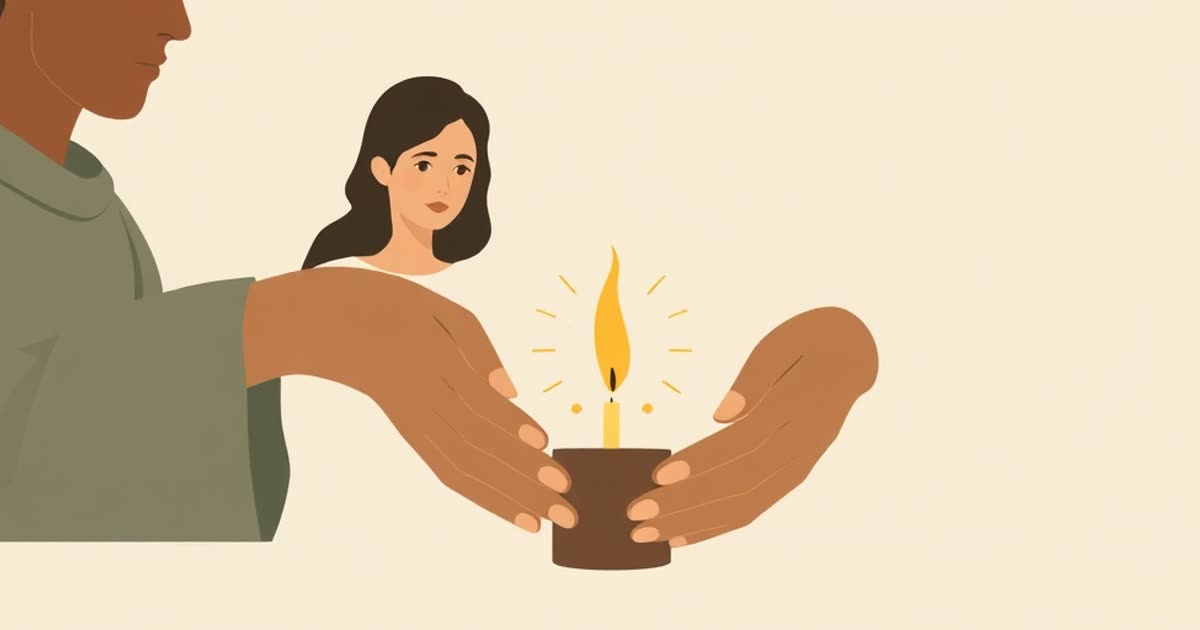 A candle burning low being gently shielded by two hands.